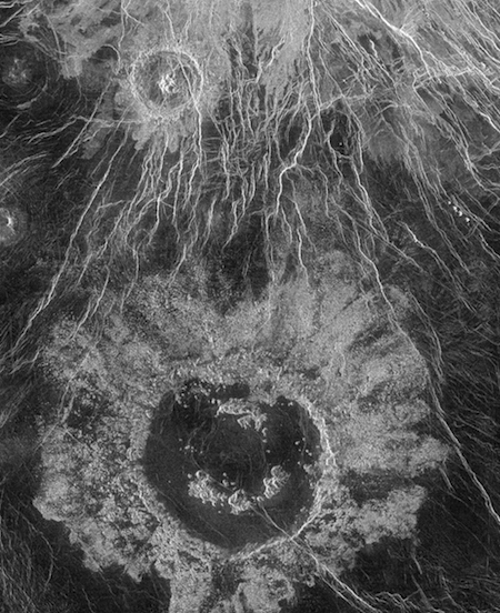 a photo of a large crater and lots of white cracks in the surface