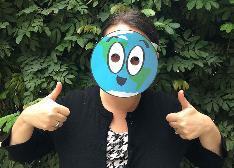 a person wearing a cartoon paper mask of the Earth