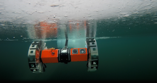 A photograph of the BRUIE robot rolling its wheels on the underside of an icy surface.