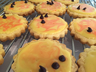 a picture of cookies with orange and yellow frosting and chocolate chips